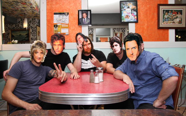 Photo of Moonlight Desires band members sitting at a red table
