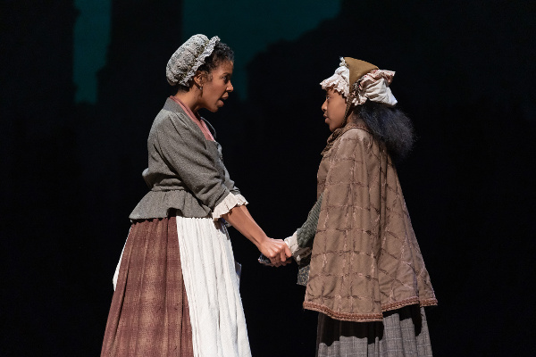 Photo of Yesenia Iglesias as Mrs. Cratchit and Ariel Russell (Martha Cratchit) in the Ford’s Theatre 2018 production of “A Christmas Carol” at Ford’s Theatre