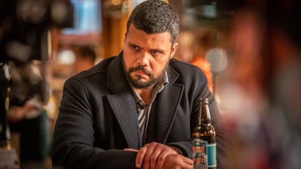 Photo of Howard Charles as Mike McGuire, sitting at a table