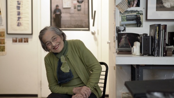 Photo of photographer Barbara Crane sitting in her studio