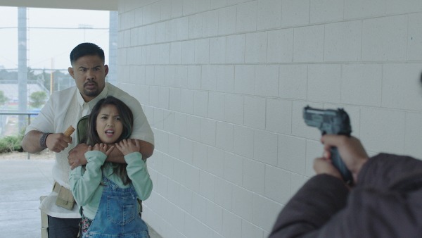 Photo of Mark Muñoz as Kuya holding April Absinth who plays Rachel for a hostage scene in the film