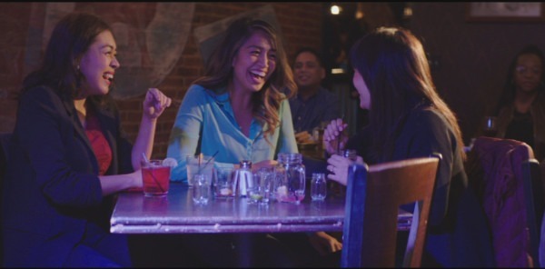 Photo of Lora Nicolas as Megan, Haven Everly as Christine, and Emy Coligado as Mary sitting and laughing at open mic night