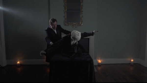 Photo of actor Dominic Gerrard with a puppet of Ebenezer Scrooge during a performance of 'A Christmas Carol'