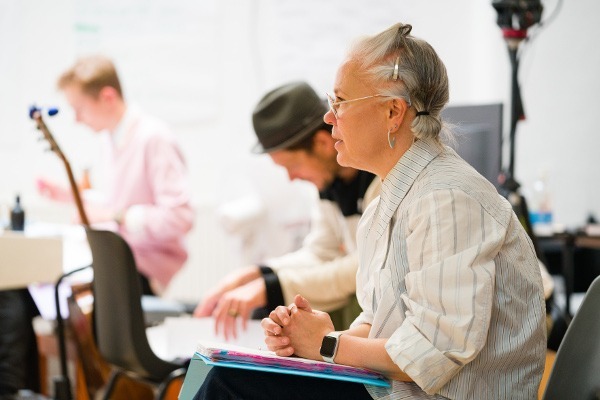 Photo of director Emma Rice sitting and watching a rehearsal