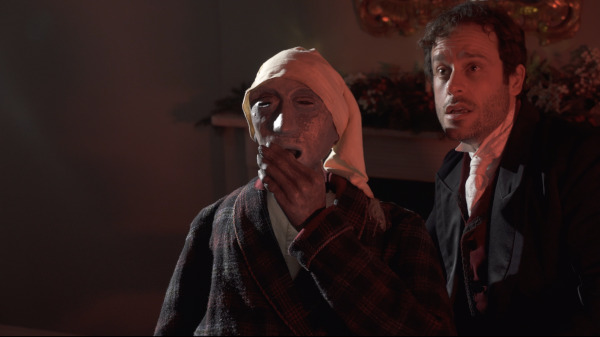 Photo of Dominic Gerrard and Scrooge puppet appearing frightened