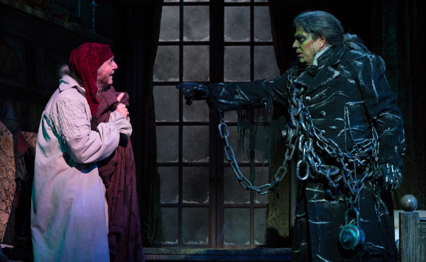 Photo of Richard Doyle as Ebenezer Scrooge and Michael Manuel as Jacob Marley in chains