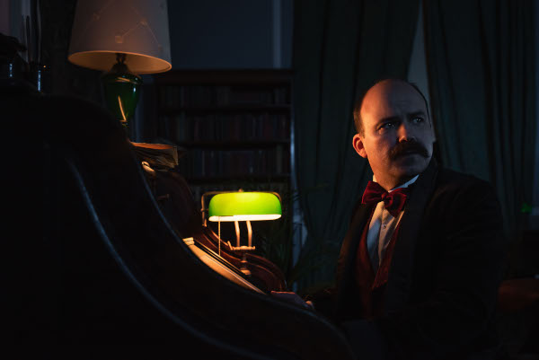 Photo of Rory Kinnear as Williams sitting in a dark room in 'The Mezzotint'