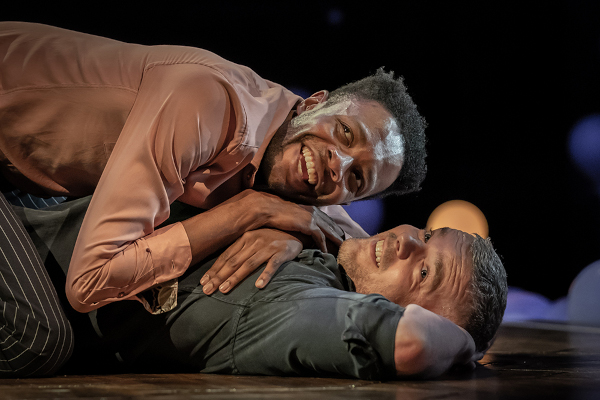 Photo of Omari Douglas and Russell Tovey lying on the stage