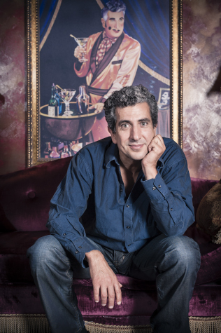 Photo of Frank Ferrante sitting on a couch in front of a painting