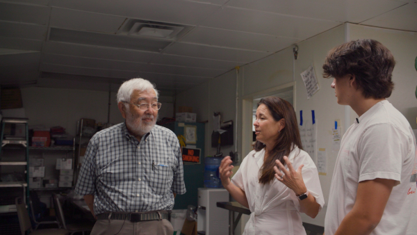 80 Years Later production still of Robert, Jenny, and Matthew standing in Soya Foods