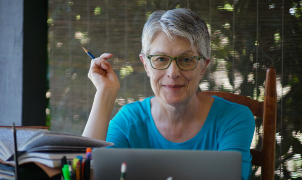 Close-up photo of Petrea Burchard sitting at her desk with her laptop and notebook open