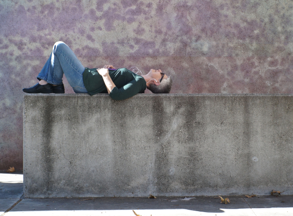 Photo of a woman lying down on a stone wall