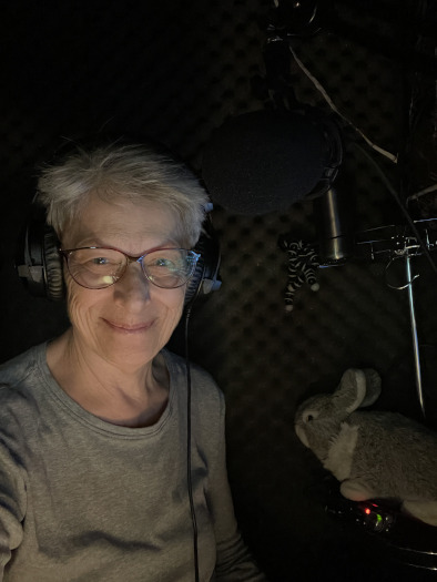 Photo of Petrea Burchard, author of 'Camelot & Vine,' wearing headphones in the recording home studio 