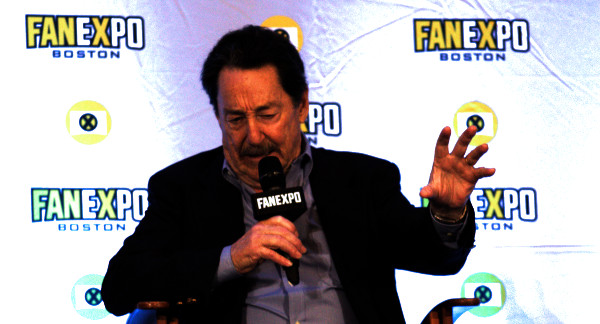 Photo of Peter Cullen speaking and holding his hand out