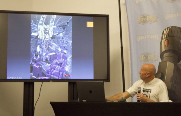 Simon Furman showing Transformers drawings on a screen