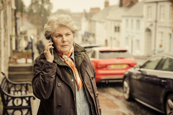 Woman standing on a street and talking on a cell phone