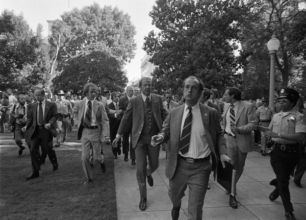 Photograph of Secret Service Agents Rushing President Gerald Ford towards the California State Capitol following the Assassination Attempt on the President by Lynette "Squeaky" Fromme, in Sacramento, California, Sept. 5, 1975. Photo from the National Archives and Records Adminstration via Wikimedia Commons